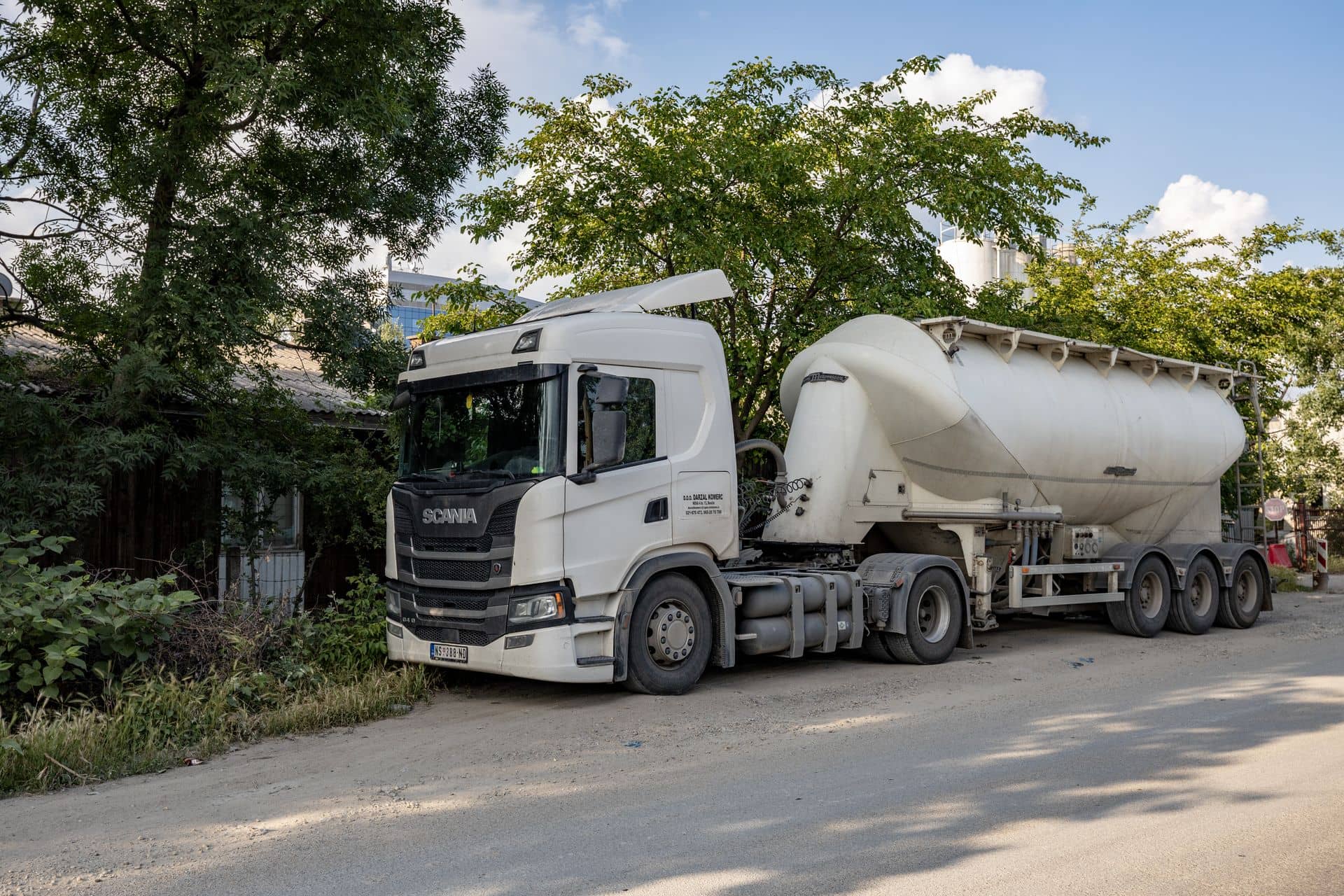 Vit tankbil med blank cistern i dagsljus